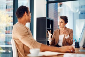 Man and woman discussing business strategy at office desk