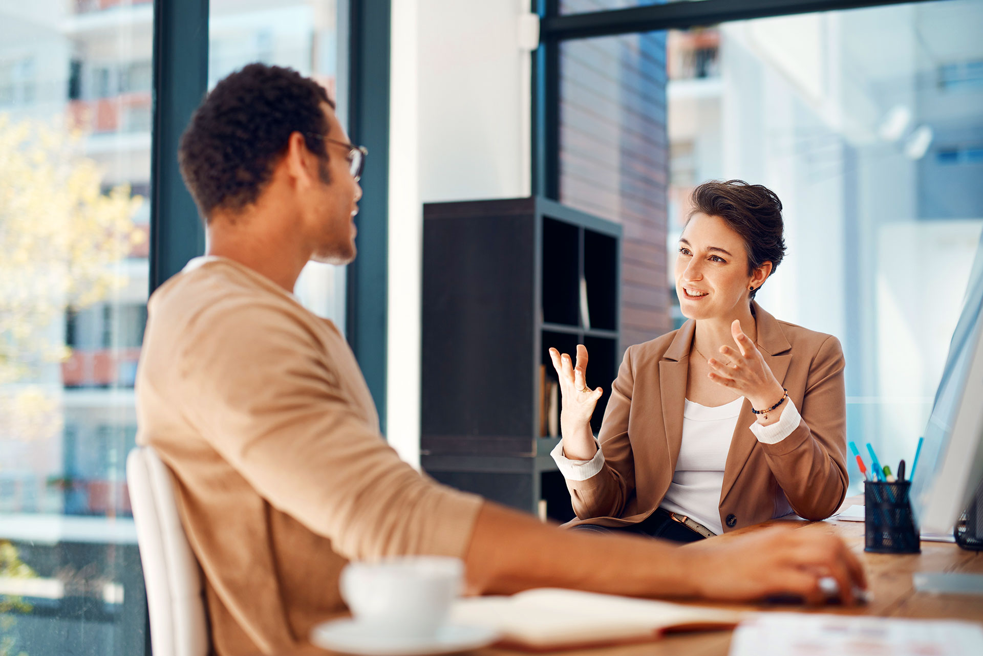 Man and woman discussing business strategy at office desk